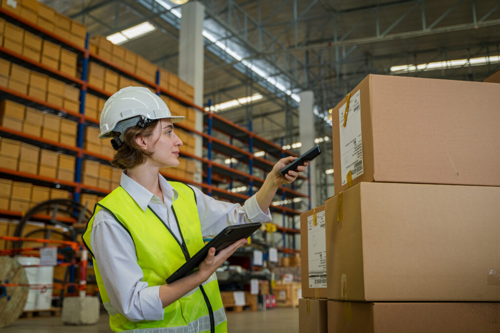 Worker scanning parcels for retail and transport shipping in warehouse stock checking.